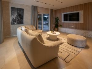 un salon avec un canapé et deux chaises et une télévision dans l'établissement Villa Corsa - luxury villa in Istria, à Barban