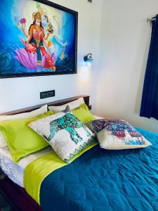 - un lit avec des oreillers et un tableau mural dans l'établissement Kesaviyam Luxury HeritageSuites Kovalam lighthouse, à Kovalam