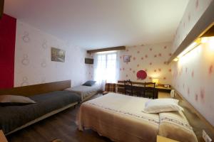 1 dormitorio con 2 camas y ventana en Logis Hôtel de France en Arudy