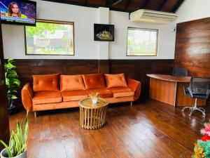 a living room with an orange couch and a table at Deduru Cabana Nature Resort in Kurunegala