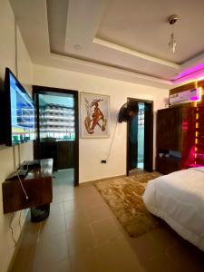 a bedroom with a bed and a desk and a television at Peridot Studio Apt maitama in Abuja