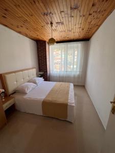 ウルツィニにあるCity Heart Apartments 2の木製の天井と大きなベッドのある寝室