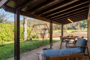 un patio con tavolo, sedie e altalena di Venade Mountain House by Portugal Active a Venade