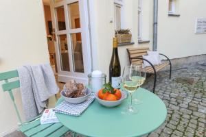 a table with a bottle of wine and a bowl of fruit at WEINQUARTIER Lindenring 45 qm 2 SZ Altstadt Küche Kaffee in Naumburg