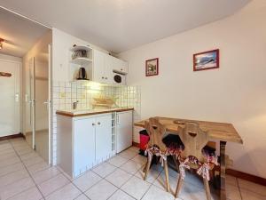a kitchen with a wooden table in a room at Studio Le Flocon à Saint-Gervais-les-Bains in Saint-Gervais-les-Bains +10 photos