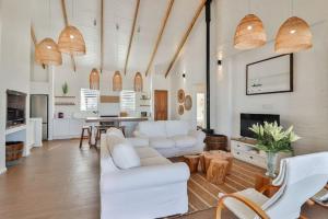 un soggiorno con mobili bianchi e un camino di Efcharisto Seaside Cottage - Lower Beach Road a Kleinmond