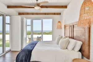 una camera da letto con un letto grande con vista sull'oceano di Efcharisto Seaside Cottage - Lower Beach Road a Kleinmond
