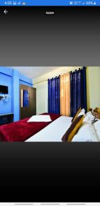 a bedroom with two beds with blue walls and curtains at Sri Sai Residency Ooty in Ooty