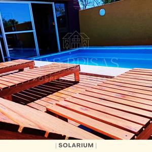 due panche di legno sedute su una terrazza accanto alla piscina di Las Brisas - Hospedaje Serrano a Santa María