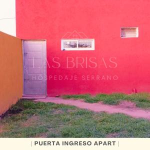 un edificio rosso con una porta di fronte di Las Brisas - Hospedaje Serrano a Santa María