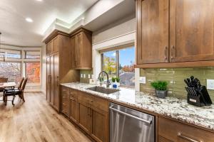 a kitchen with wooden cabinets and a sink and a table at Troutner East Boise Home in Boise