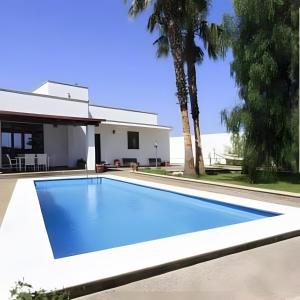 a swimming pool in front of a house at Villa Leonardo con piscina privata in Tiggiano