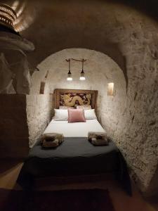 切列梅萨皮卡Conibianchi Trulli & YurtArt House的一间卧室，石墙内有一张床