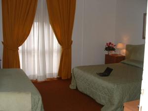 a bedroom with a bed and two lamps at Hotel Barberino in Barberino di Mugello