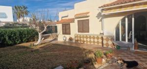 a dog sitting in the yard of a house at Villa Evelina Puerto Rey Vera in Vera