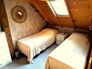 two beds in a room with a window at Vakantiehuis Het Wonder in Siegerswoude
