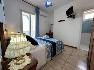 a bedroom with a bed and a lamp on a table at Hotel Giglio in Lampedusa