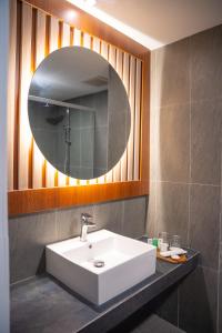 a bathroom with a white sink and a mirror at D'girijati Resort And Beachclub in Girijati +4 photos
