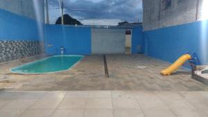 a room with a swimming pool and a slide at Clube com Piscina in Andradina