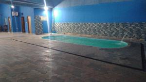 a swimming pool in the middle of a room at Clube com Piscina in Andradina