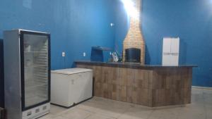 a bar in a room with a blue wall at Clube com Piscina in Andradina