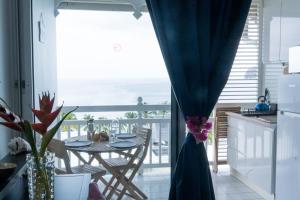 a kitchen and dining room with a view of the ocean at Gap Caraïbes in Le Diamant