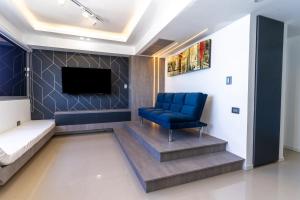 sala de estar con silla azul y TV en Alojamiento en Lecheria PV2, en El Morro de Barcelona