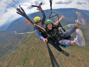 two people are flying in a parachute at ADVENTURE Hostel in San Gil +38 photos