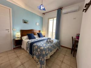 a bedroom with a bed with blue walls and a window at Hotel Giglio in Lampedusa