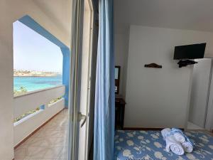 a bedroom with a bed and a view of the ocean at Hotel Giglio in Lampedusa