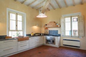 a large kitchen with white cabinets and a stove at I Magazzini in Marti