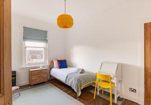 a bedroom with a bed and a desk with a laptop at Harvieston in Elie