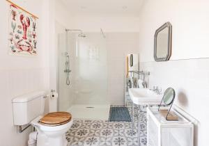 a white bathroom with a toilet and a sink at Harvieston in Elie