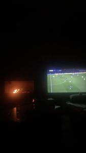 a television in a dark room with a soccer game at Luxury House in Shkodër