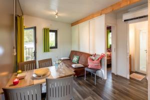 a living room with a table and a couch at Camping Sole Di Sari in Sari Solenzara