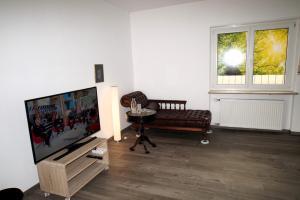 a living room with a flat screen tv and a chair at Ruhepol in Wiesloch
