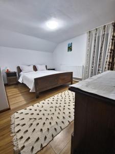 a bedroom with a bed and a rug at Casa Chindea Lacu Rosu in Lacu Rosu