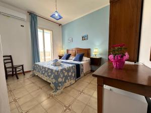 a bedroom with a bed with blue walls and a window at Hotel Giglio in Lampedusa