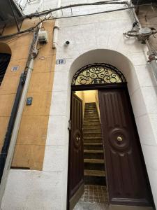 巴勒莫Vicoletto Ludovica - Proppro SRL- Palermo的一道棕色的门,楼梯通往大楼