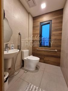 a bathroom with a toilet and a sink and a window at Salablanca Brand New Jacuzzi Heated Pool PS5 VR Cinema Fully AC Indoors Smart TVs with Netflix Disney Plus Large Balcony in Tagaytay +17 photos