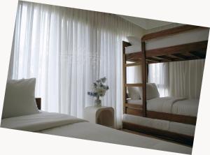 a bedroom with two bunk beds and a window at Salablanca Brand New Jacuzzi Heated Pool PS5 VR Cinema Fully AC Indoors Smart TVs with Netflix Disney Plus Large Balcony in Tagaytay