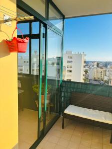 a balcony with a bench and a basket at Armaçao de Pera - T1 Proche Mer et commodités in Armação de Pêra +2 photos