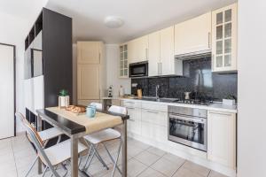 a kitchen with white cabinets and a table with chairs at Emerald Wave - House on the beach with pool in Torre Grande