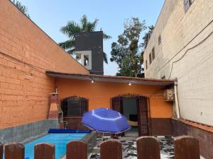 a house with a swimming pool with a blue umbrella at Kit net great price in São Sebastião