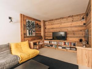 Appartement Triplex Cosy pour 6 Personnes, Centre de Val d'Isère, Proche Pistes - FR-1-567-109 في فال ديزير: غرفة معيشة مع أريكة وتلفزيون