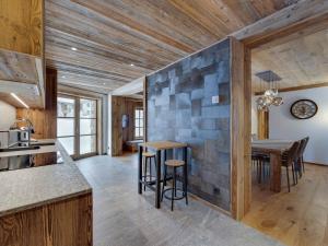 a kitchen and dining room with a stone wall at Appartement 6 pers. avec terrasse près des pistes, cheminée et parking, Val d'Isère - FR-1-567-111 in Val dʼIsère