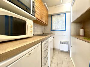 a kitchen with a microwave and a sink at REF 033 Appartement T3 vue mer Les Terrasses de Kerjouanno Arzon in Arzon +11 photos