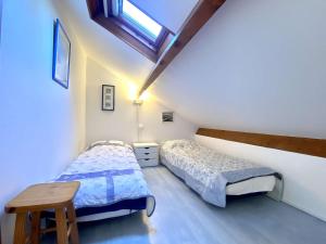 a bedroom with two beds and a table in it at REF 033 Appartement T3 vue mer Les Terrasses de Kerjouanno Arzon in Arzon