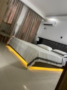 阿布贾Peridot apt maitama的一间卧室配有一张大床,卧室配有黄色的igunigunigunigunigunigunigunigunigun