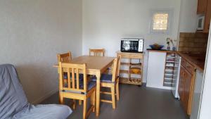 a kitchen with a table and chairs in a room at REF 042 Appartement T2 avec balcon et piscine Arzon in Arzon +9 photos